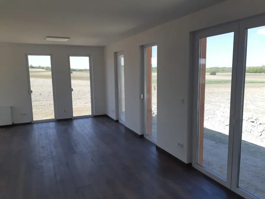 Ein Zimmer des Musterhauses mit Glastüren zur Terrasse